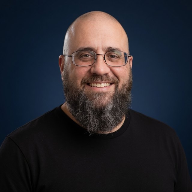 Barry “Odinn” Walter, founder of RNK Academy, smiling, in a black T-shirt against a navy background